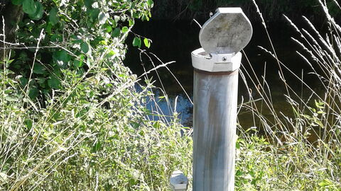 Grundwassermessung Messgerät auf Wiese neben Bach
